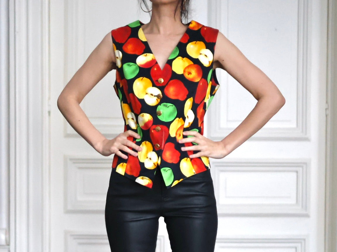Silhouette glamour et futuriste autour d’un gilet vintage ESCADA Margaretha Ley à imprimé pommes. Une allure contemporaine mêlant cuir noir, bottines sculpturales et pop vintage des années 80-90. Pau Wu Pauwu