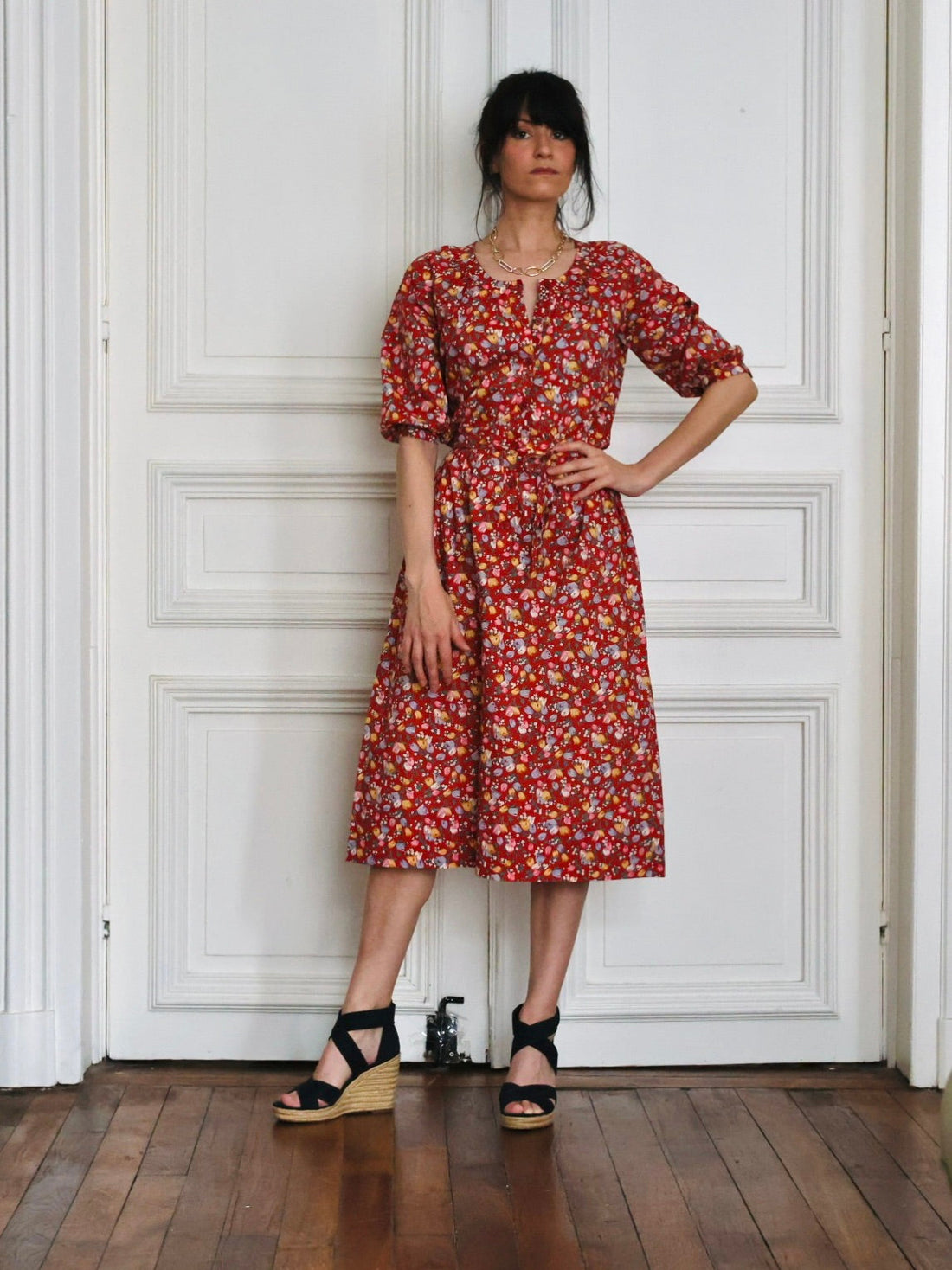 Robe vintage Guy Laroche en coton à imprimé floral liberty rouge brique, portée avec des espadrilles compensées noires et un collier doré., disponible dans e-shop vintage créateurs 