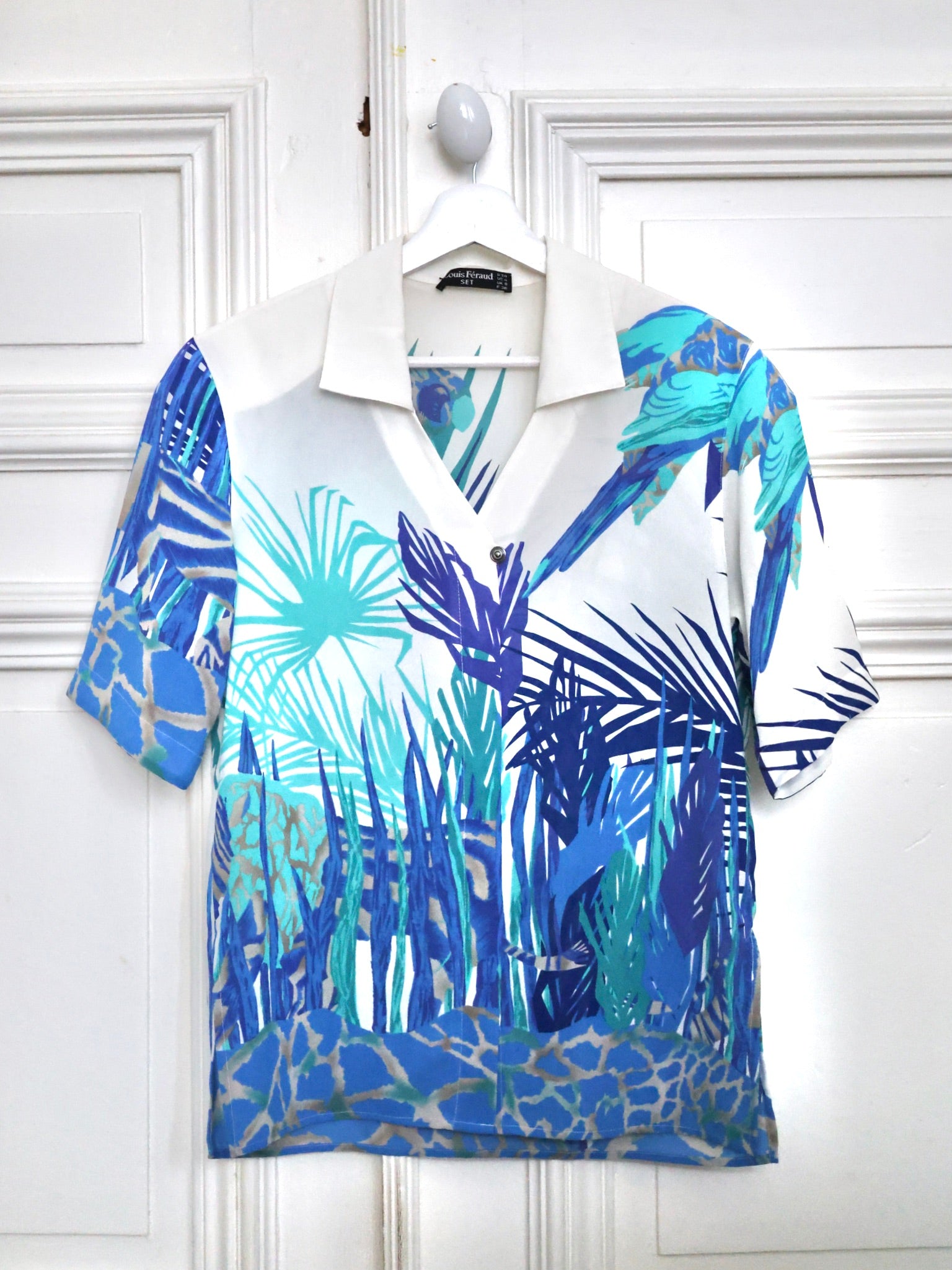 Ce chemisier vintage Louis Féraud 80s à imprimé jungle turquoise est une pièce emblématique des années 80, facile à porter avec un jean, un pantalon tailoring ou une silhouette plus rock en cuir noir. Boutique mode vintage, blog mode, Pau Wu, Pauwu