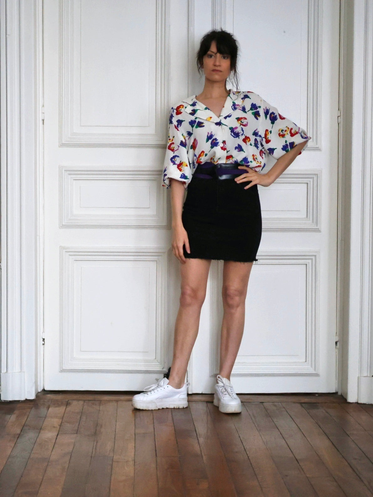 Chemisier Lanvin vintage associé à une jupe noire, une ceinture Ungaro et des baskets blanches