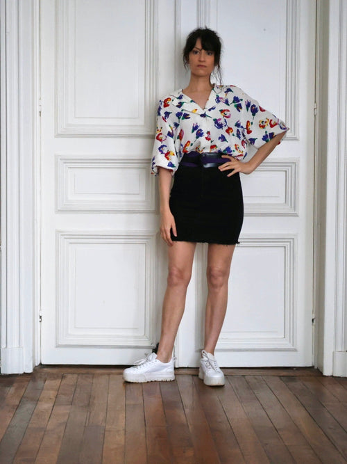 Chemisier Lanvin vintage associé à une jupe noire, une ceinture Ungaro et des baskets blanches