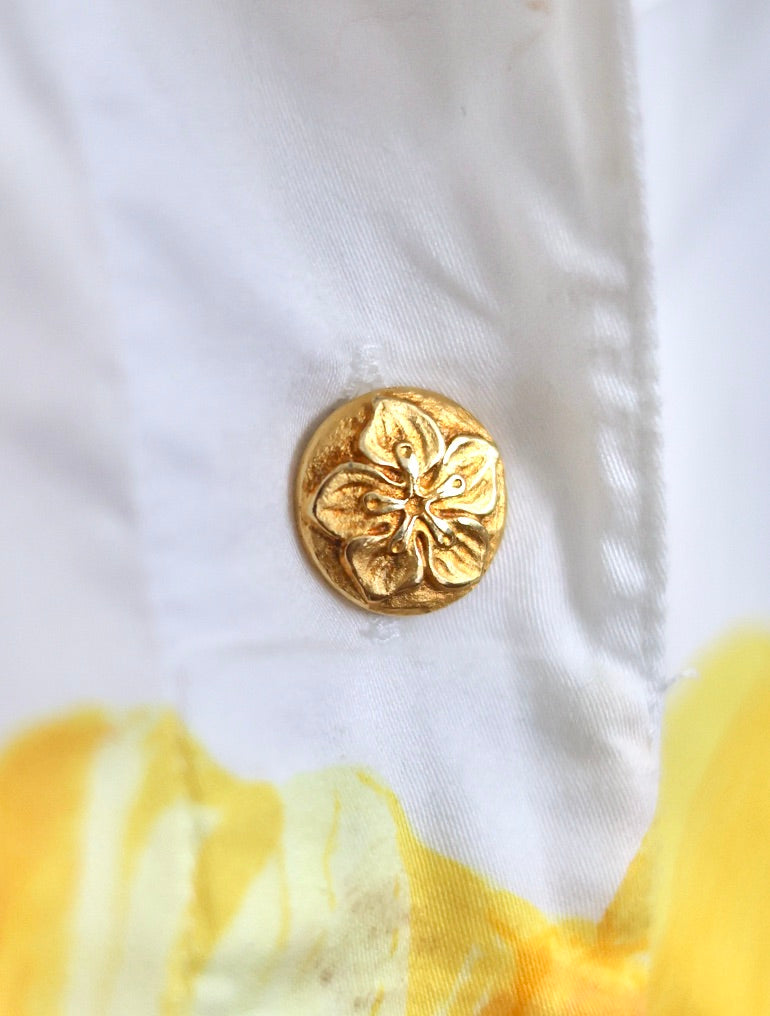 Gros plan sur les boutons bijoux dorés en forme de fleurs d'une chemise vintage Escada en coton.